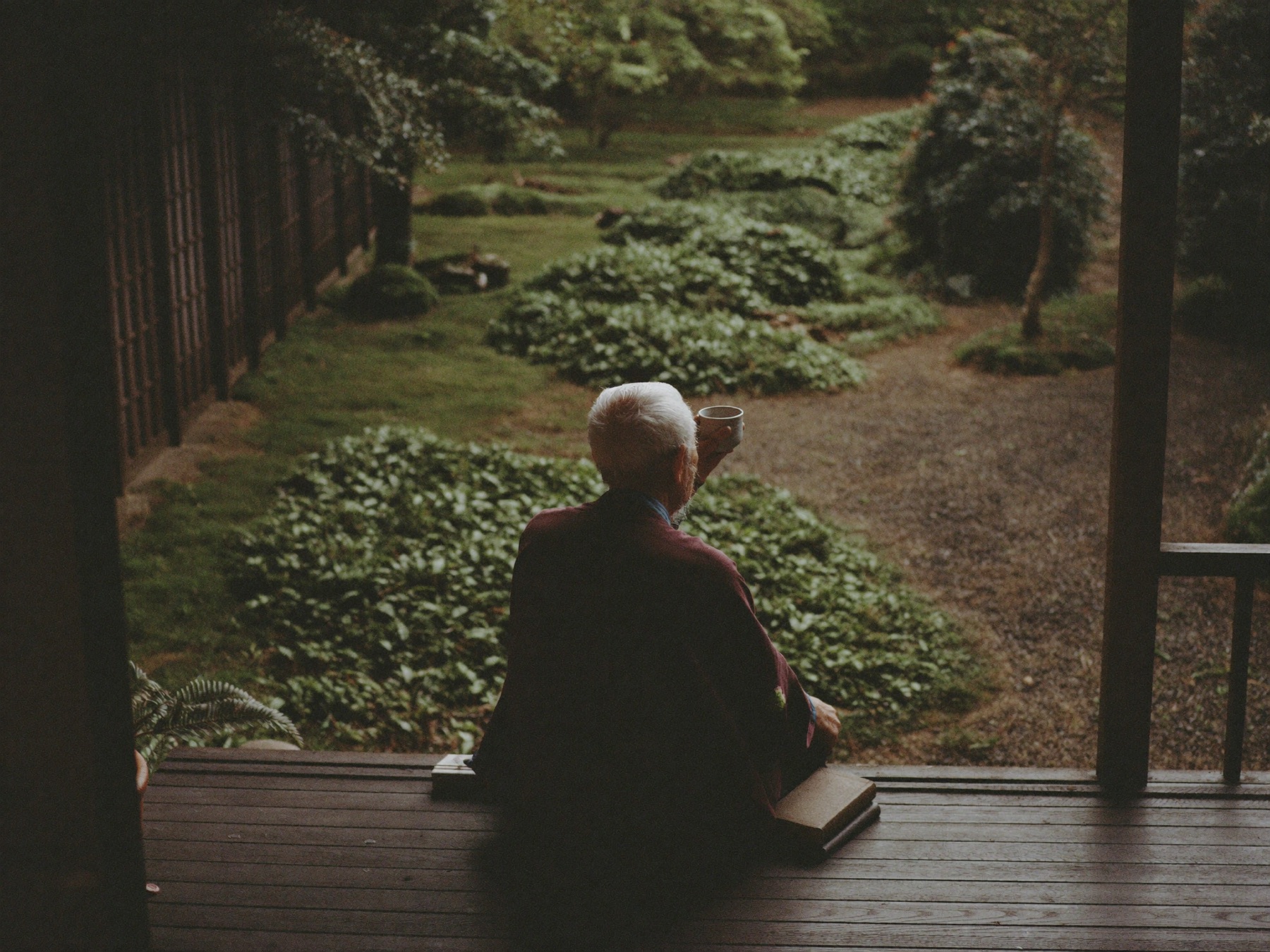 縁側に座り、庭を眺めるお父さんの後ろ姿