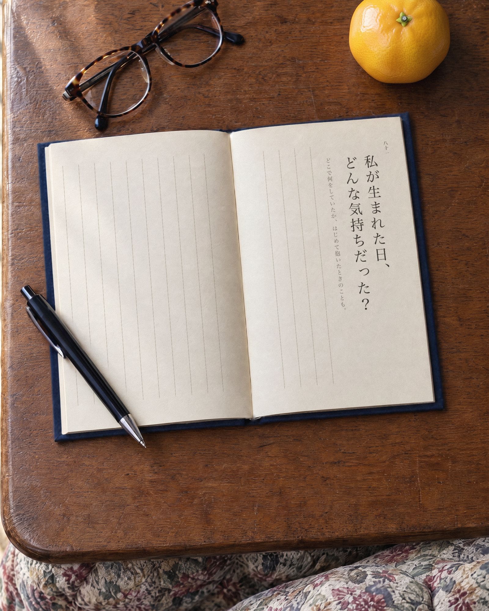 こたつの上にひらいた『きかせて、父さん』。右のページに八十一問目「私が生まれた日、どんな気持ちだった？」が印刷され、答えを書く罫線はまだ空いている