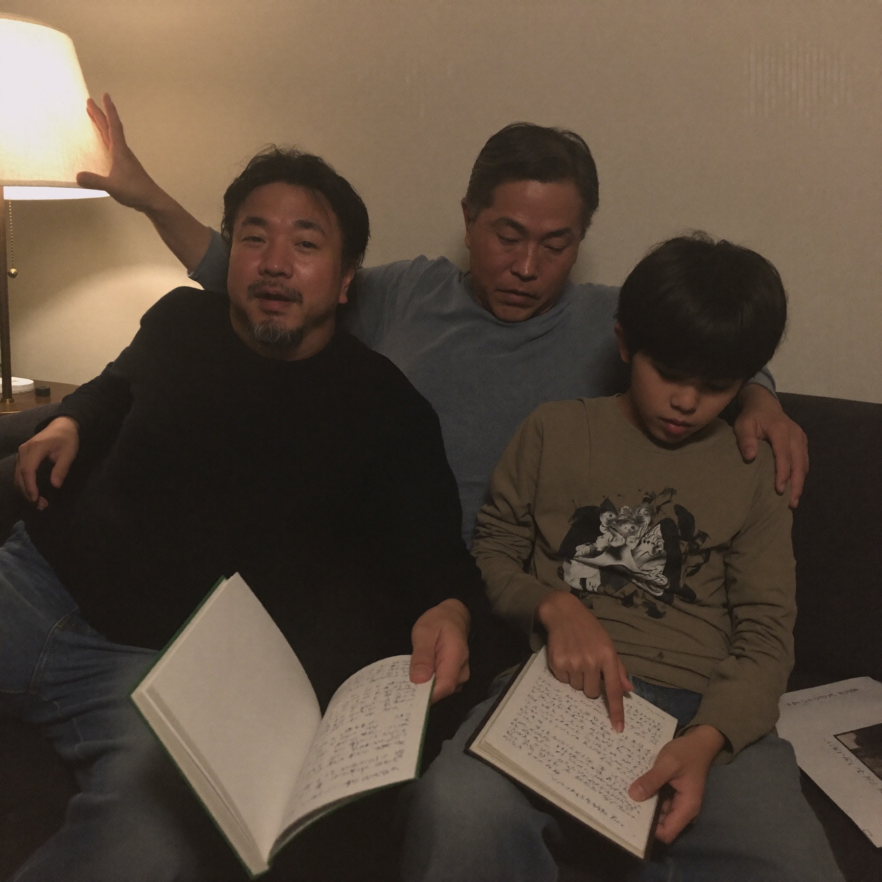 ソファで一緒にページをめくる親子